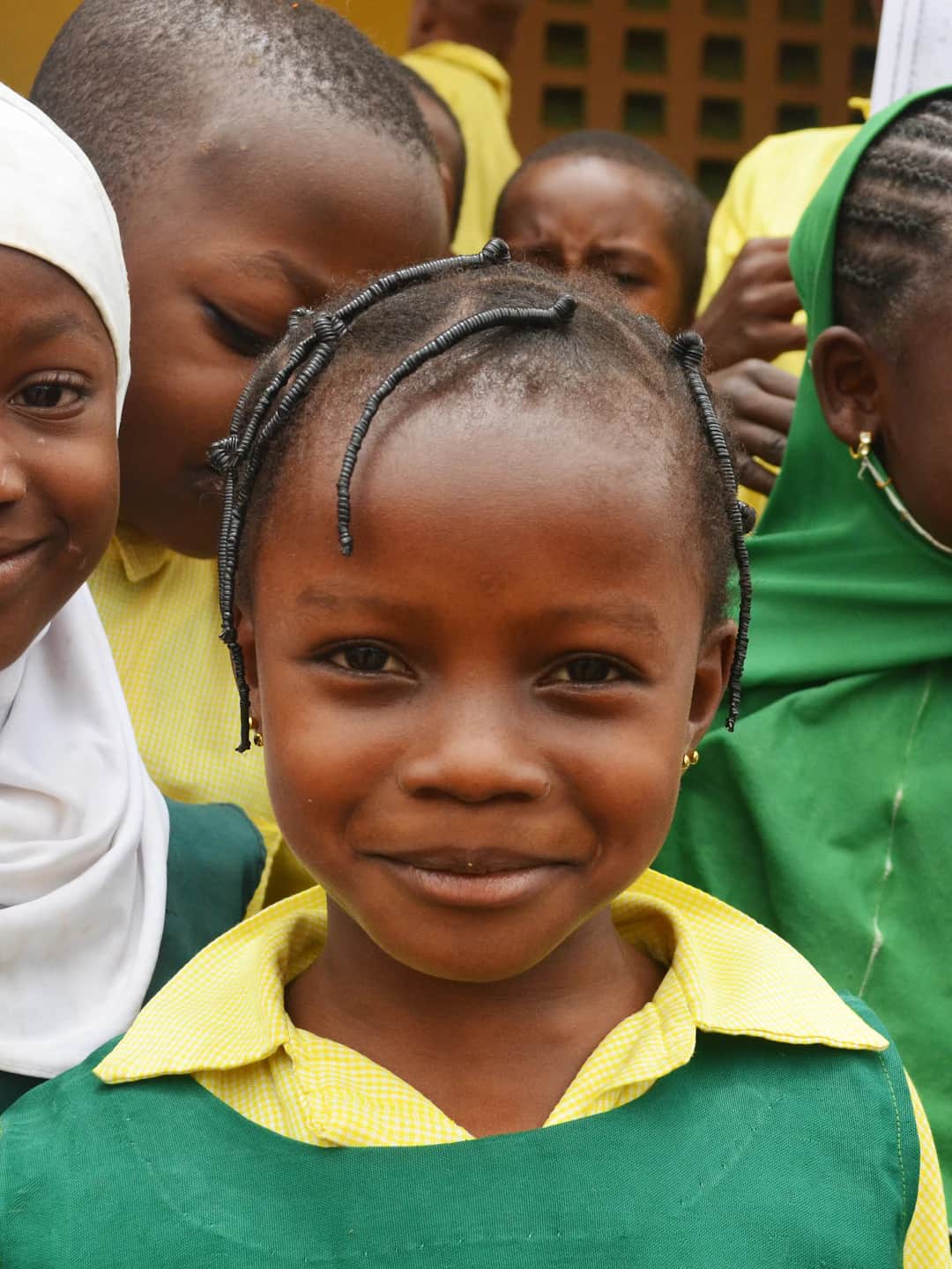 A Nigerian junior-secondary student in a green-and-white school uniform.
